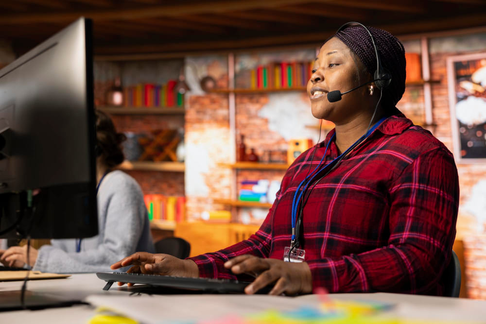 Support centre d'appels professionnel tapant sur le clavier du PC aidant les clients